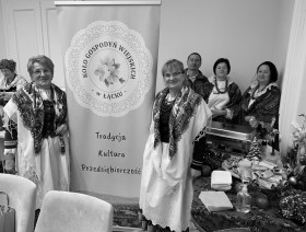 Kobiety z Koła Gospodyń Wiejskich w Łącku, ubrane w stroje góralskie z prawej strony stół zastawiony potrawami.