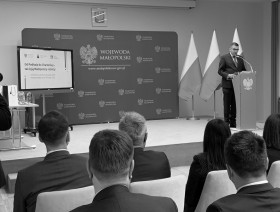 Sala konferencyjna z uczestnikami konferencji. Z prawej strony przemawiający Wojewoda Małopolski Łukasz Kmita.